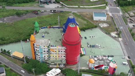 Aerial-above-view-capturing-touristic-attraction-colorful-lucky-art-crayon-factory,-DIY-experience-center-for-children-and-family-and-townscape-at-Yilan-County,-Taiwan