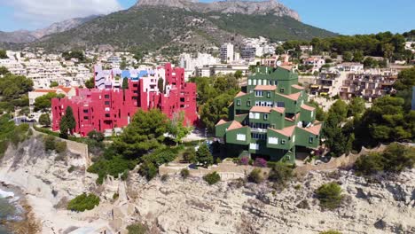 A-view-of-the-colorful-La-Muralla-Roja-building,-in-Calpe,-Spain,-an-apartment-building-designed-by-Ricardo-Bofill-and-built-in-1972
