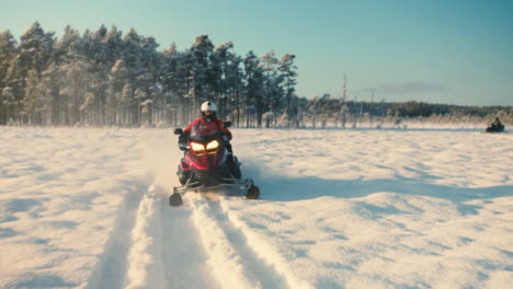 Man-on-a-Snowmobileturning-quickly-on-a-snowy-lake-a-sunny-winterday