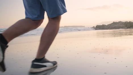 Beach-jogger-wearing-Puma-running-shoes-jogs-on-wet-beach-during-sunset