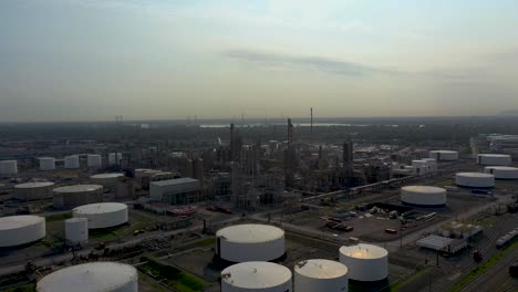 Aerial-shot-moving-in-and-around-an-oil-refinery-in-a-summer-sky-in-Montreal,-Quebec,-Canada