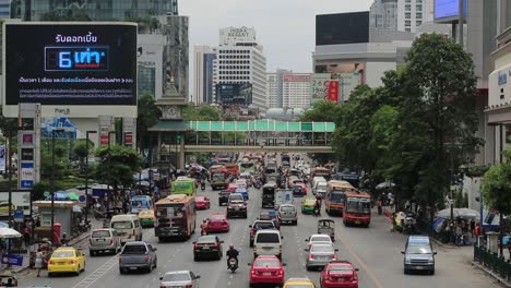 Stark-Befahrene-Straße-Mit-Skywalk-Und-Plakatwand-Im-Stadtzentrum-Von-Bangkok