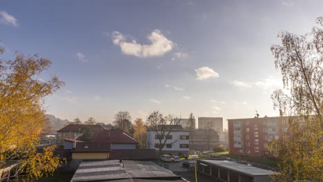 Zeitraffervideo-Des-Wohnviertels-Der-Stadt-Bei-Tiefstehendem-Nebel-Und-Sonnenschein-über-Dem-Boden-Mit-Verkehr-Auf-Der-Hauptstraße-Und-Ziehenden-Wolken