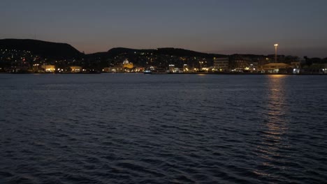 Pan-up-revealing-Mytilene-city-at-dusk-wide-shot