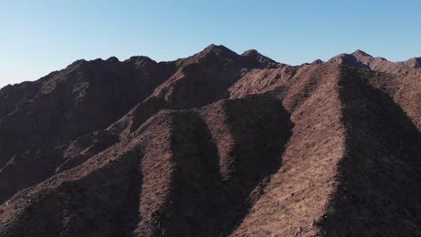 Beautiful-dry-arid-desert-mountain-ridge-landscape-by-interstate-highway-below-in-valley,-aerial
