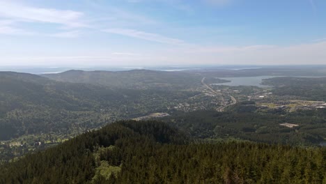 Malerische-Luftaufnahme-Vom-Gipfel-Des-Berges-Mit-Blick-Auf-Immergrünen-Wald-Und-Die-Stadt-Im-Hintergrund-Im-Bundesstaat-Washington