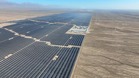 Flying-over-vast-renewable-energy-resource-solar-farm-in-arid-desert-area---slow-descending-aerial-closeup-view