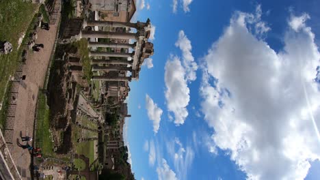 Vertikale-Aufnahme-Des-Forum-Romanum,-Rom,-Italien,-Kameraschwenk-Von-Links-Nach-Rechts-An-Einem-Schönen-Frühlingstag-Mit-Blauem-Himmel-Und-Weißen-Wolken