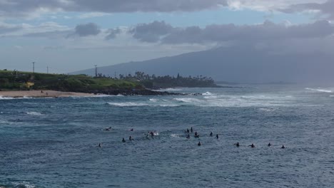 Los-Surfistas-Reman-Esperando-En-La-Alineación-En-Hookipa-Surf-Break-En-Un-Hermoso-Día-Tropical-En-Maui,-Hawaii