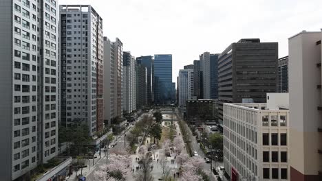 Luftdrohne-Fliegt-über-Die-Wolkenkratzertürme-Und-Menschen-Im-Stadtzentrum-Von-Seoul,-Südkorea