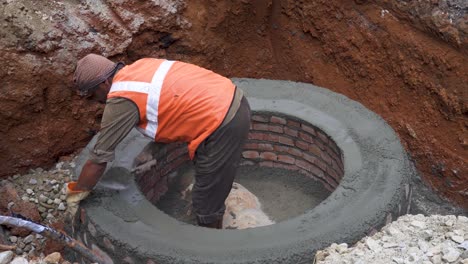 Indian-labourer-or-worker-constructing-a-manhole-in-the-streets-of-Bangalore,-India