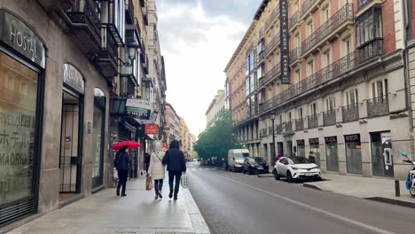 Gente-Caminando-Tranquilamente-En-Medio-Del-Centro-De-La-Ciudad-De-Madrid-En-Un-Día-Lluvioso.
