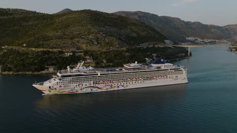 Aerial-5K-Drone-View-Of-Norwegian-Star-Cruise-Ship-Sailing-Out-Of-Dubrovnik,-Croatia-On-Scenic-European-Cruise