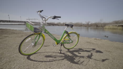 This-is-a-static-shot-of-a-Green-Bike-with-White-Rock-Lake-in-Dallas,-TX-behind-it
