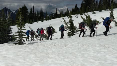 Excursionistas-Que-Comienzan-Su-Viaje-A-La-Cumbre-Del-Monte-Rainier,-Parque-Nacional-Monte-Rainier,-Mochilas,-Nieve,-Cuesta-Arriba