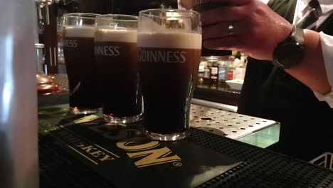 Unseen-bartender-serving-pints-of-Guinness-in-a-Bar