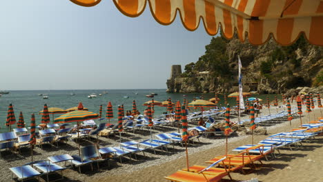 Eine-Wunderschöne-Italienische-Strandszene-Mit-Bunten-Sonnenschirmen-Und-Dem-Blauen-Meer
