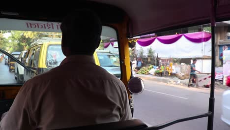 Shoulder-Shot-Of-Auto-Rikshaw-Driver-Driving-On-Busy-Indian-Road