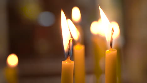 Extreme-Close-Up-Shot-of-Candles-Burning-And-Flame-Waving-Inside-of-Madaba-St-George's-Greek-Orthodox-Church,-100-Frames-Per-Second