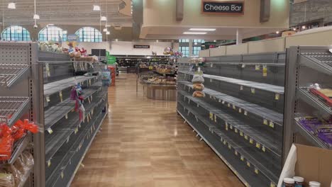 Wide-shot-Harris-Teeter-bread-aisle-empty-and-sold-out-due-to-coronavirus-COVID-19-panic-buying-shelves-empty-staff-working-in-the-background-to-restock