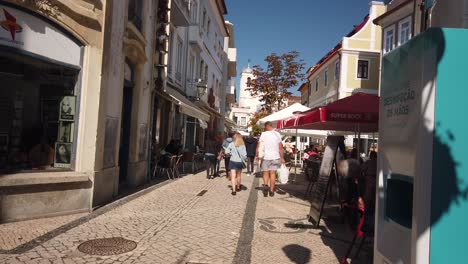 Turista-Caminando-Por-Las-Calles-De-Aveiro-En-Portugal,-Usando-Máscaras-Protectoras-Y-Estación-De-Desinfectante-De-Manos