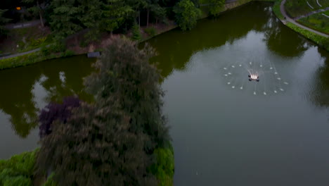 Fast-flying-drone-above-a-large-park-with-a-pond,-city-park-berg-en-bos-in-Apeldoorn