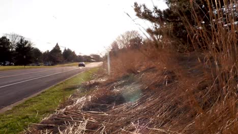 Coche-Conduciendo-Hacia-El-Atardecer-A-Lo-Largo-De-Una-Carretera-Asfaltada-Vacía-En-Bloomington-Minnesota