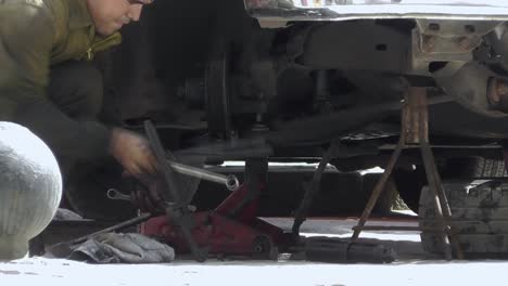 Cuban-mechanic-in-working-overall-repairing-vintage-car-in-local-city-street-of-Old-Havana