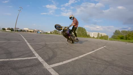 Stunt-biker-spins-on-one-wheel,-filmed-with-an-FPV-drone-in-60-fps