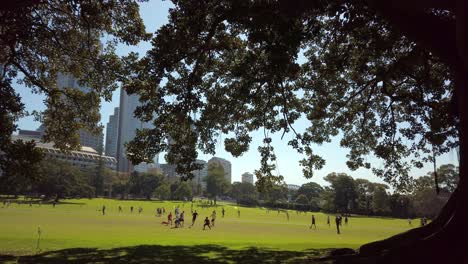 Office-workers-playing-a-friendly-soccer-game-during-a-lunch-break-in-a-park