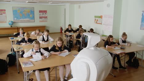 Roboterlehrer,-Futuristische-Schule,-Erzählt-Etwas.-Totale-Aufnahme-Eines-Klassenzimmers-Voller-Schüler,-Die-Ihre-Hausaufgaben-Oder-Hausaufgaben-Machen