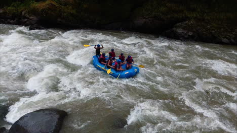 white-water-rafting-group-does-rally-cheer-with-paddles-before-continuing-in-Costa-Rica-jungle-rapids
