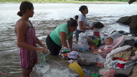 Las-Mujeres-Y-Los-Niños-Lavan-Su-Ropa-A-Mano-En-El-Río-Local.