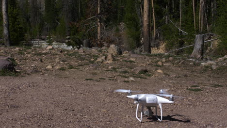 Drone-taking-off-on-gravel-with-river-in-background