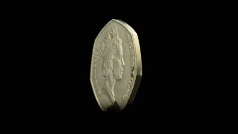 A-dirty-coin-spins-slowly-against-a-black-background