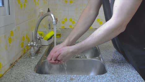 Male-person-washing-his-hands-at-home