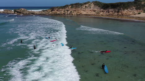 Aerial:-Student-on-blue-surfboard-is-launched-into-small-shore-break