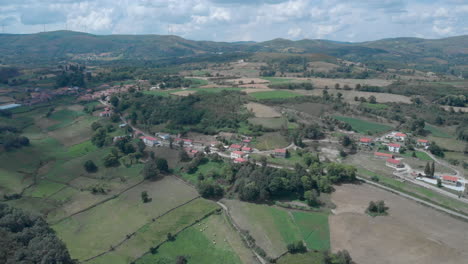 Aerial-panning-shot-of-a-remote-vilage-in-the-north-of-Portugal-with-windmills-in-the-backround
