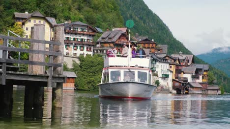A-ship-with-visitors-passes-though-the-Hallstatter-See-in-Hallstatt,-Austria