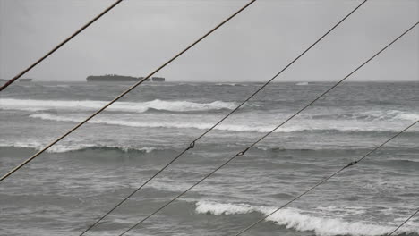 Scenic-View-Of-Waves-Rolling-At-The-Sea-Through-The-Rigging-Of-A-Sailboat---wide-shot