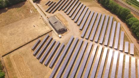 Eine-Kleine-Solarpanel-Farm-Überführung-Mit-Einem-Zug,-Der-Vom-Feld-Direkt-Neben-Dem-Gelände-Angetrieben-Wird