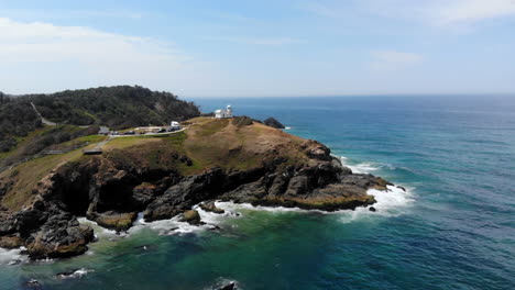 Aerial-Orbit-View-of-The-Tacking-Point-Lighthouse-at-Port-Macquarie-Australia,-Rocky-Headland-Hill,-Ocean-and-Landscape-in-Background