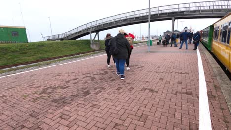 Hyper-lapse-shot-following-people-getting-out-from-a-train-at-the-railway-station,-cloudy-day,-in-Langeoog,-Germany
