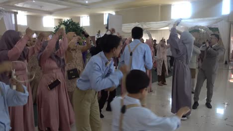 Family-and-all-wedding-audience-doing-flash-mob,-dance-together-for-happy-groom-and-bride-on-wedding-day