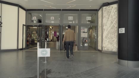 People-entering-shopping-mall-with-face-masks-in-Brussels,-COVID-19-coronavirus