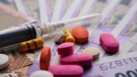 Medical-Treatment-Expenses-Concept,-Pills,-and-Syringe-On-Indian-Currency-zoom-View