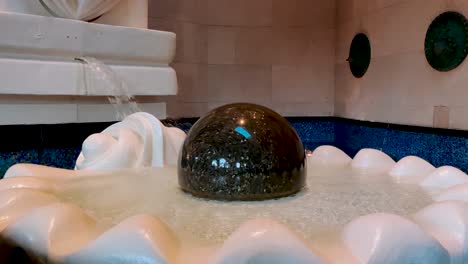 Majestic-fountain-with-spinning-dark-shining-stone-ball-in-Atlantis-hotel-in-the-Bahamas,-Nassau