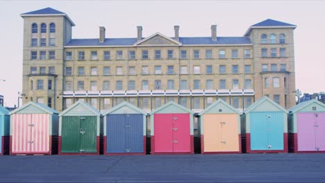 Mujer-Con-Un-Perro-Paseando-Por-Las-Cabañas-De-La-Playa-De-Brighton