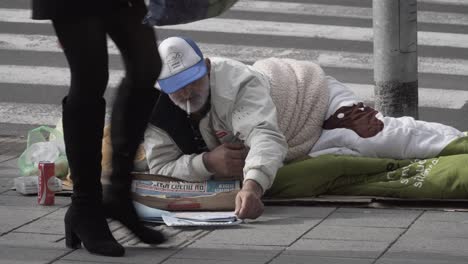 A-homeless-person-begging-for-money-laying-on-the-street-of-Tel-Aviv