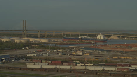 Mobile-Alabama-Aerial-v10-Flying-low-over-industrial-trainyard-area-with-cityscape-views-at-sunset---March-2020